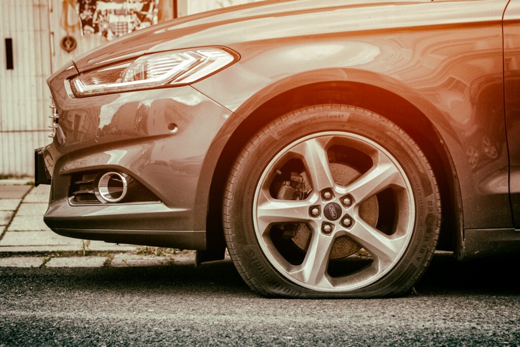red mercedes benz c class with flat tire